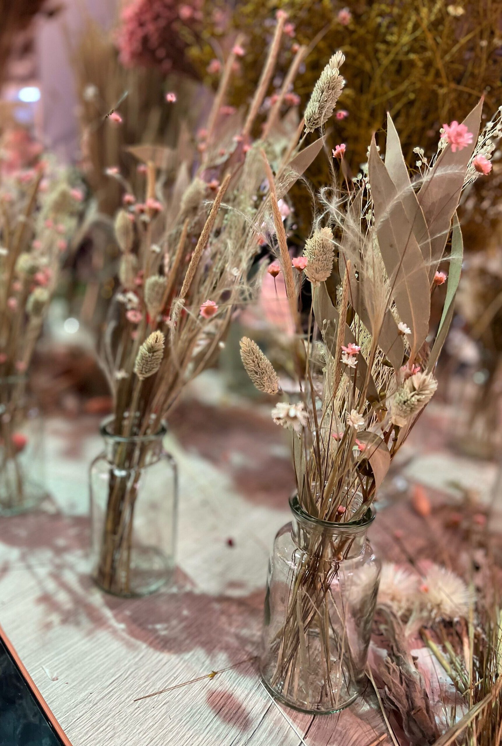 Dekorative Trockenblumen in kleinen Glasvasen